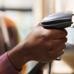 tipos de leitores de código de barras cabetc blog homem segurando leitor de códigos